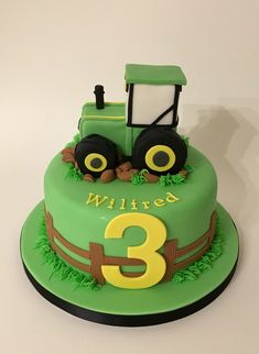 a green birthday cake with a tractor on the front and number three on the side