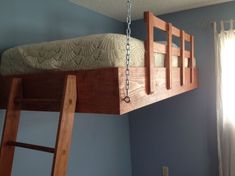 a wooden bunk bed suspended from the ceiling