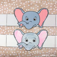 two elephant cut outs sitting next to each other on top of a sheet of paper