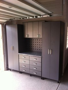 a garage storage area with cabinets and drawers