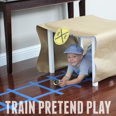 a small child is playing with a train pretend play set