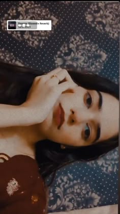 a woman laying on top of a bed next to a pillow