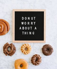 donuts and doughnuts on a table with a sign that says donut worry about a thing