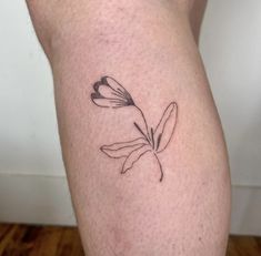 a small black and white flower tattoo on the leg