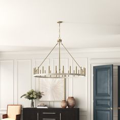 a living room with white walls, blue doors and a chandelier hanging from the ceiling