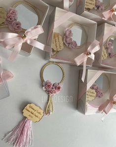 pink flowers and tassels are on display in small boxes with tags attached to them