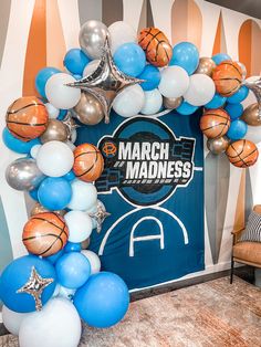 a balloon arch is decorated with basketballs and balloons for a march madness party in the office