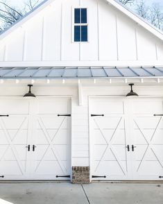 two white garage doors are open in front of a house