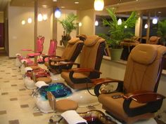 there are many chairs lined up in the hairdressers room, all different colors and sizes