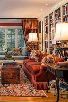 a living room filled with lots of furniture and bookshelves next to a window