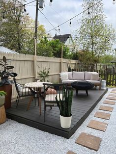 an outdoor patio with potted plants on the deck and seating area in the background