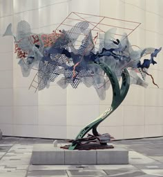 a sculpture is shown in front of a white building with blue and red designs on it