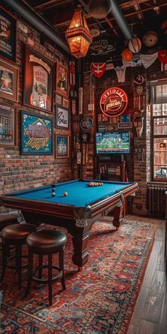 a pool table in the middle of a room with many pictures on the wall above it