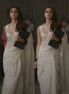 a woman in a white sari holding a book