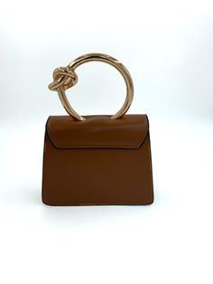 Gold circular handle structured handbag with detachable crossbody chain. Brown Satchel With Round Handle And Gold-tone Hardware, Brown Satchel With Gold-tone Hardware And Round Handle, Trendy Top Handle Shoulder Bag With Gold-tone Hardware, Top Handle Satchel With Handles As Fashion Accessory, Trendy Evening Bag With Gold-tone Hardware And Top Handle, Brown Satchel With Detachable Round Handle, Trendy Handheld Box Bag With Gold-tone Hardware, Modern Shoulder Bag With Chain Strap And Top Handle, Box Bag With Detachable Handle In Crossbody Style