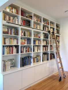 a ladder leaning up against a bookshelf filled with lots of bookcases