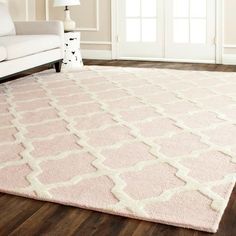 a living room with a white couch and pink rug