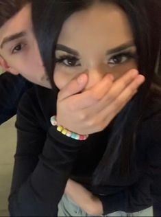 two people are posing for the camera with their hands on their face and one is covering her mouth