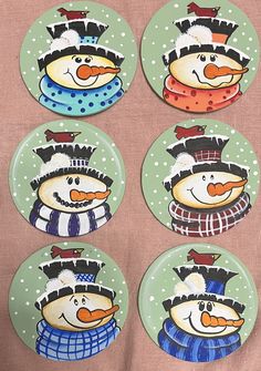 four snowmen on green plates with white polka dots