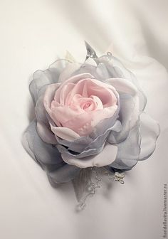 a pink and grey flower on white fabric