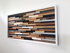 a wooden wall hanging on the side of a white wall