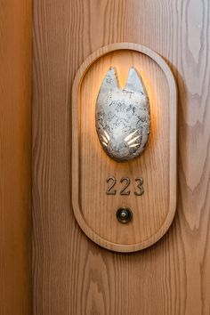 a wooden door with a metal object on it's face and numbers below the number