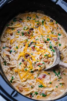 a crock pot filled with chicken, beans, and cheese in the slow cooker