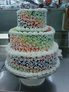 a multi - tiered cake with swirl designs on the top and bottom is displayed in a store