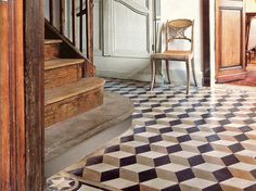 a chair sitting on top of a checkered floor in front of a door and stairs