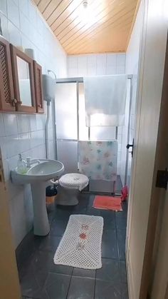 a bathroom with a toilet, sink and shower stall in the middle of the room