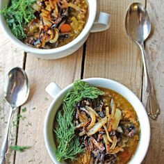 two bowls filled with soup on top of a wooden table