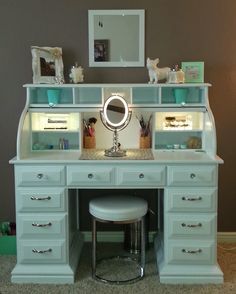 an image of a blue vanity with mirror and stool on the bottom shelf in front of it