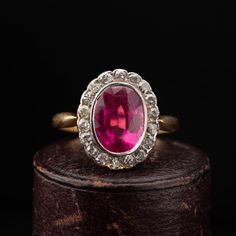 A beautiful Victorian oval cluster ring dating circa 1900, handcrafted in 18k yellow gold with a Platinum top, featuring a synthetic Ruby surrounded by 18 old cut diamonds weighing combined approx. 0.90 carat. The shoulders narrow as they meet the cluster giving a slim and elegant look to the ring. Period: Vitorian 1900s. Condition: Good condition commensurate to age. Material: 18k yellow gold, weighing 3.6 grams, acid tested. Gemstone: Oval synthetic Ruby measuring 9mm x 7mm, set in Platinum. D Victorian Ruby Ring, Antique 14k Gold Cluster Ring With Gemstones, Antique Yellow Gold Cluster Ring With Gemstone, Victorian Yellow Gold Diamond Ring With Gemstone, Victorian Ruby Cluster Ring With Gemstones, Victorian Ruby Cluster Ring For Wedding, Victorian Gemstone Cluster Wedding Ring, Victorian Gemstone Cluster Ring For Wedding, Victorian 14k Gold Cluster Ring With Gemstone