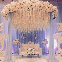 an elegant wedding setup with white flowers and blue drapes