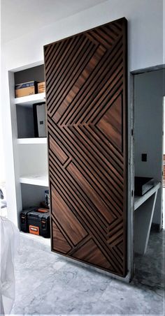 a large wooden door sitting inside of a living room next to a book shelf filled with books