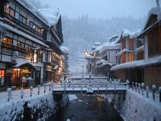 a snow covered street with buildings and lights