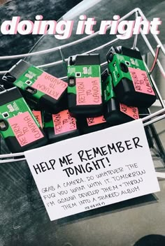 a bunch of pink and green boxes sitting on top of a metal rack next to a sign that says help me remember tonight