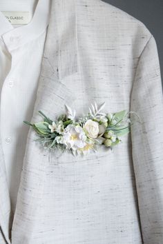 a white suit with flowers on the lapel