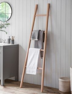 a wooden ladder leaning against the wall with towels on it