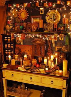 a table with candles and pictures on the wall above it in a room decorated with lights