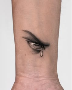 a woman's eye with tear coming out of the side of her left leg