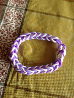 a purple and white bracelet sitting on top of a table