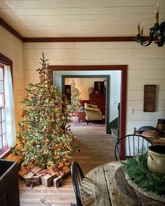 a living room with a christmas tree in the corner and other decorations on the table