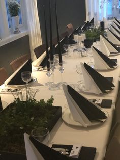 the long table is set with black and white place settings