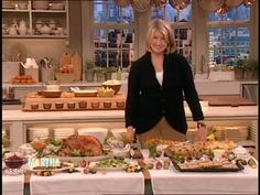 a woman standing in front of a table full of food