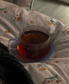 a cup of tea sitting on top of a bed