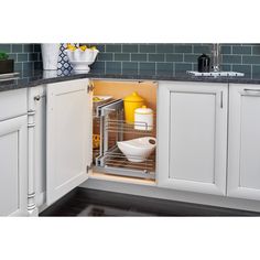 an open cabinet in a kitchen with white cabinets