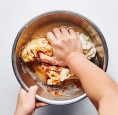 a person is washing their hands in a pot full of chicken and dumpling sauce