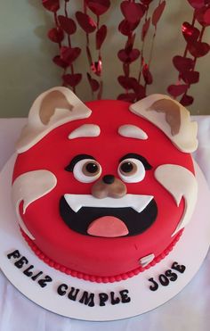 a red and white cake with an angry face on it's side that says table cumple jobs