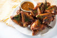 a white plate topped with wings covered in sauce